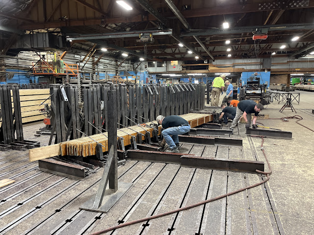 Workers prep wood lamination molds and clamps