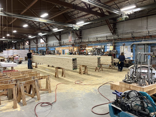 workers add finishing touches to 3 large wooden laminated beams