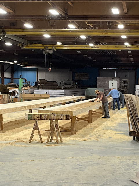 workers prepare laminated surfaces of a beam