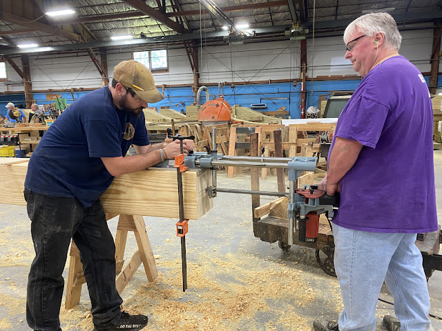 Workers use a special plunge saw which is clamped on the beam.