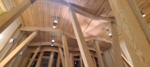 Interior view of a wooden ceiling with laminated beams and lights, designed by Unalam.