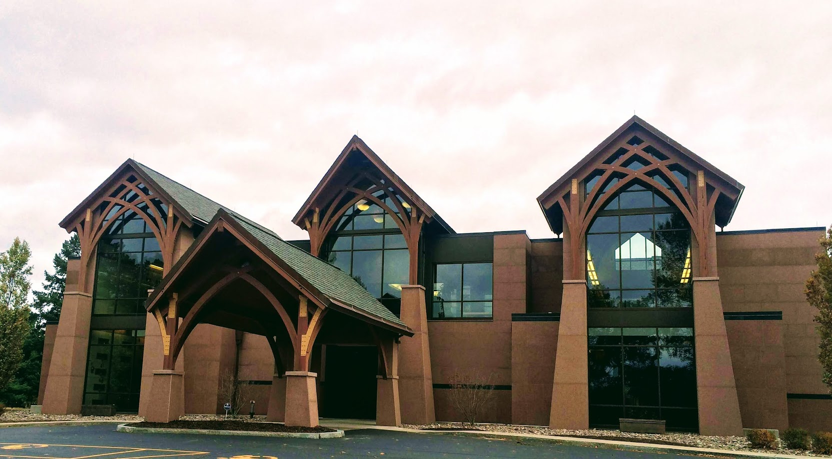 Unalam's building featuring wooden beam architecture and large glass windows.