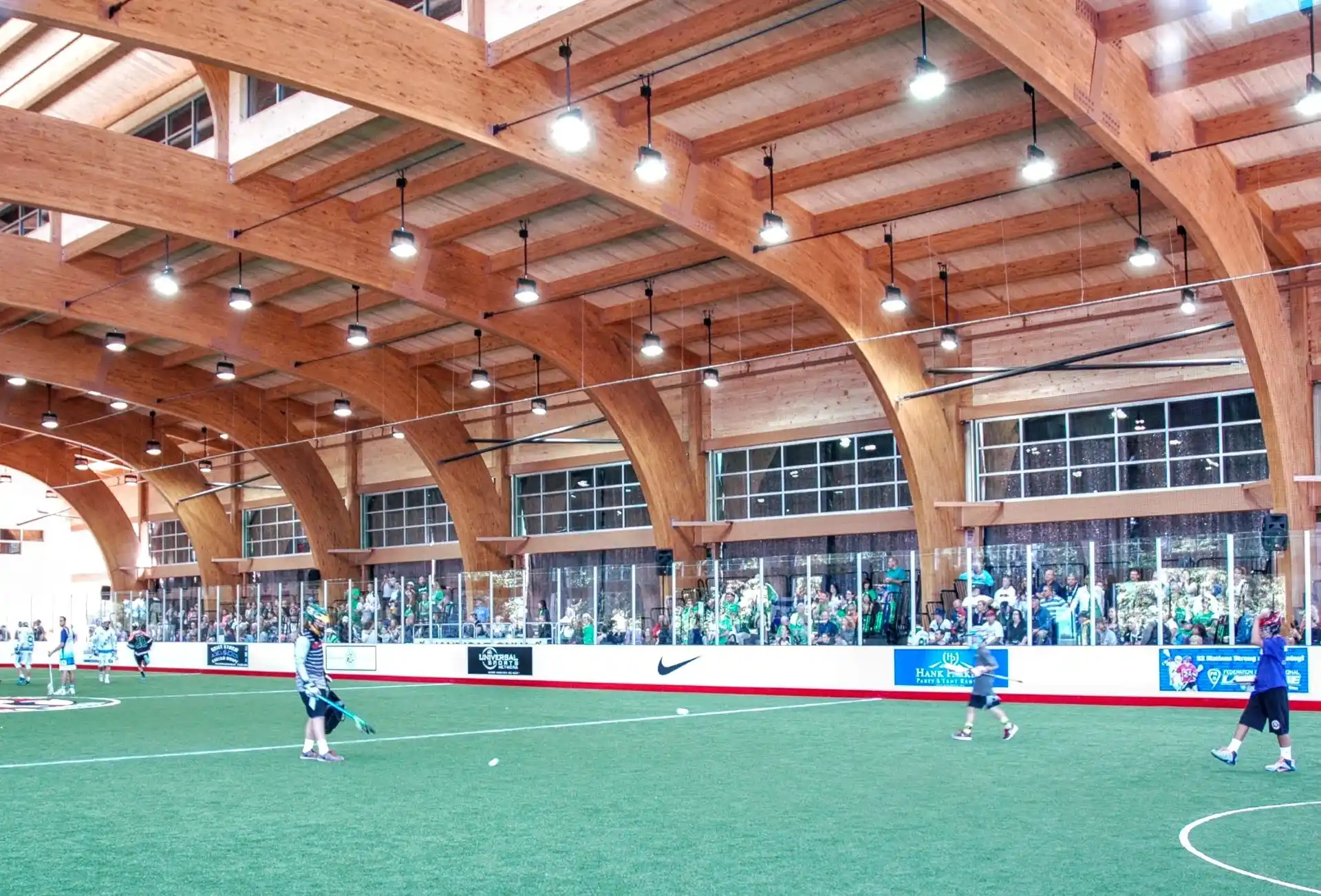 Wood laminate construction beams in an indoor sports facility with spectators.