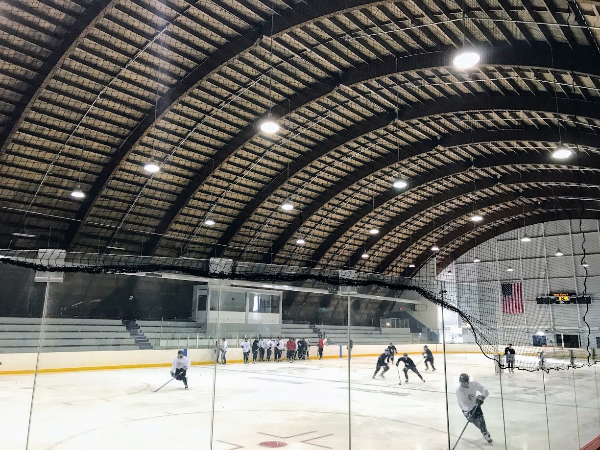Wood laminate construction beams support a hockey arena's curved roof.