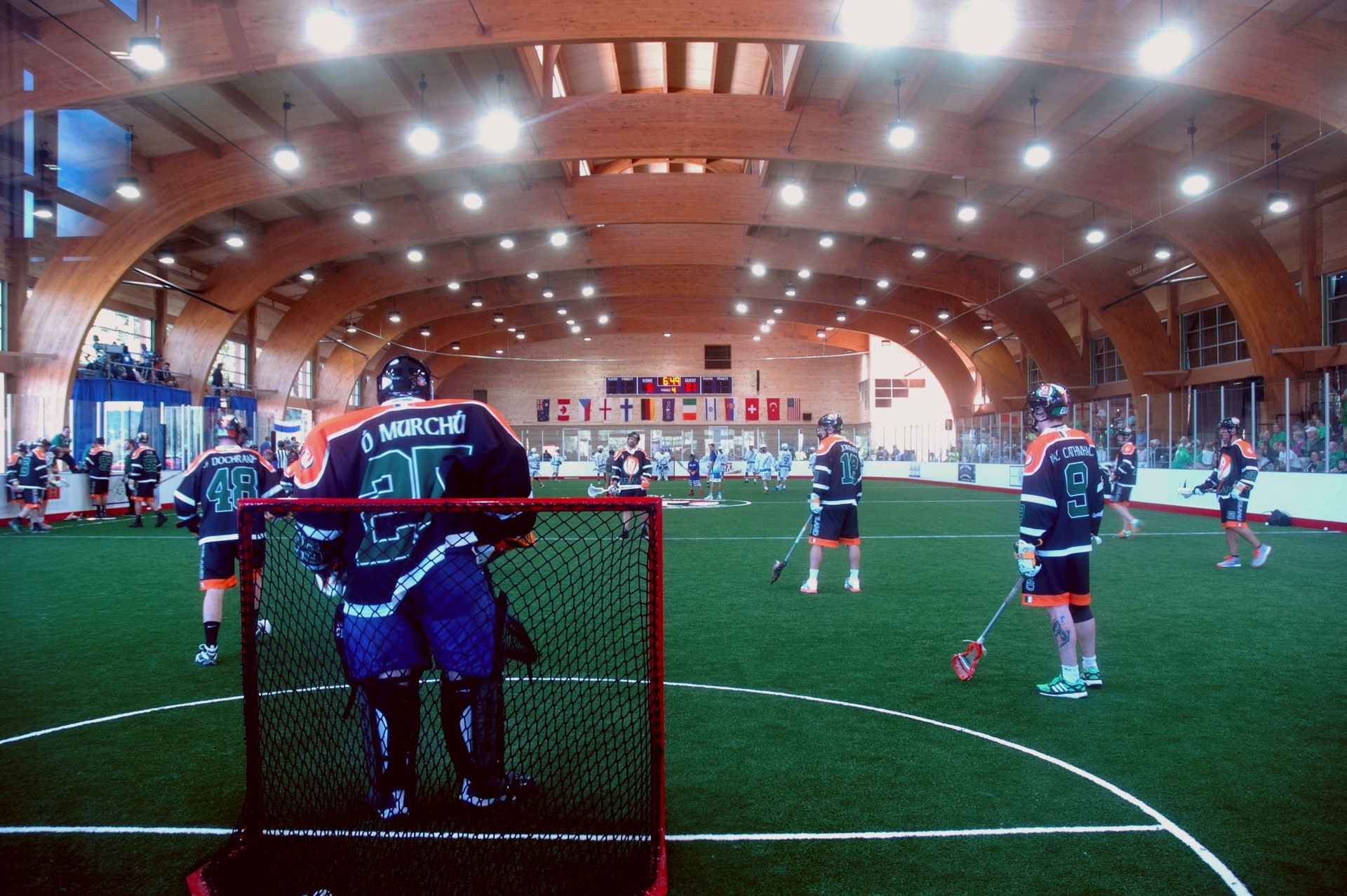 Indoor lacrosse game featuring wood laminate construction beams in the arena.