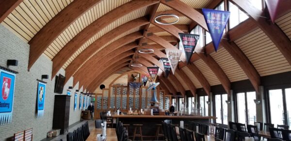 Interior view of a space with wood laminate construction beams and banners overhead.