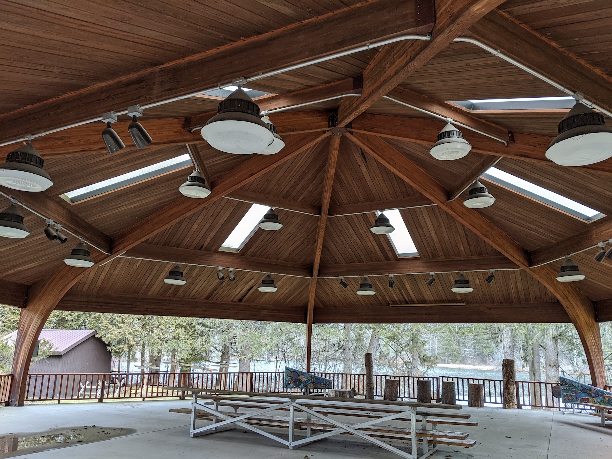 Interior of a pavilion featuring Unalam wood laminate beams and skylights.